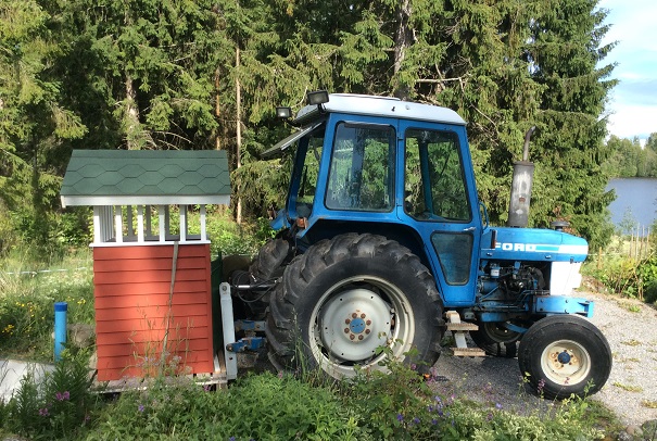 Traktorin avulla toimitetaan roskakatosta kylätien varteen.